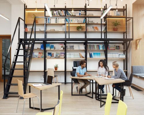 Group of business partners on meeting discussing company profits, making research, looking through ompetieour's work on laptop.Business, teamwork concept.